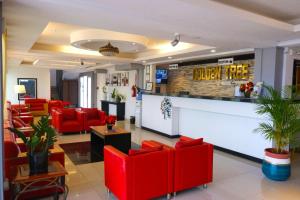 伯利兹城Golden Tree Hotel Belize的一间设有红色椅子和柜台的等候室