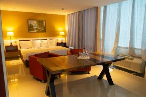 伯利兹城Golden Tree Hotel Belize的酒店客房设有一张床和一张木桌