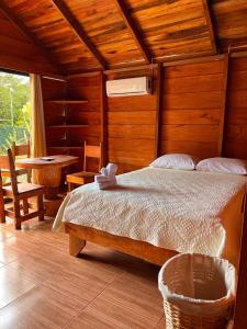 福尔图纳Cabañas SyC的卧室配有一张床铺,位于带桌子的房间