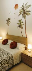 钱皮诺F.A.M. ROOMS的卧室配有一张墙上棕榈树床。