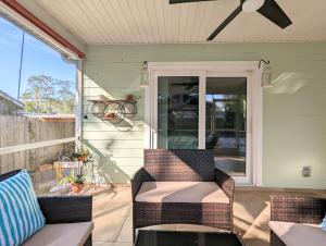 萨拉索塔3Bed & 2Bath Property Couple minutes from Siesta Key Beach & Downtown Sarasota的门廊配有2把椅子和吊扇