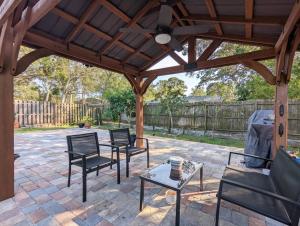 萨拉索塔Mint Home of Siesta Key's 3/2 & Serene Patio!的一个带椅子的庭院和木制凉亭