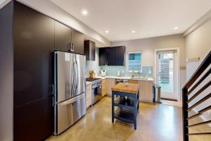 西雅图Luxury Ballard Townhome的厨房配有不锈钢冰箱和桌子