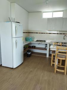 阿扬格Imelda House的厨房配有白色冰箱和桌子