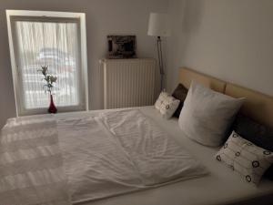 Freiroda莱比锡机场旅馆的卧室配有带枕头的白色床和窗户。