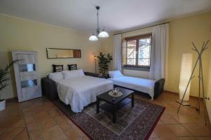 比萨Villa Fiore Luxury Pool & Garden的一间卧室配有两张床、一张沙发和一张桌子