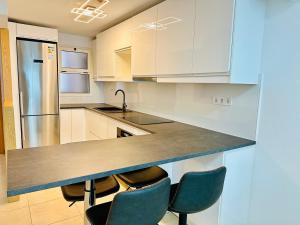 库拉海滩APARTMENT WITH OCEAN VIEW的厨房配有白色橱柜和带椅子的柜台。