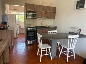 弗洛里亚诺波利斯Residencial Mizinho的厨房配有柜台和2把白色椅子