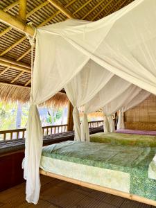 吉利阿尔吉利埃尔椰子旅舍的帐篷内的一张床位,配有蚊帐