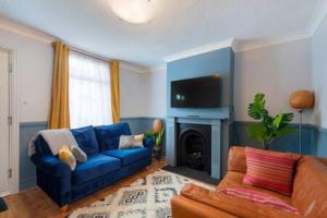 克罗伊登Cosy 2-bedroom house in Croydon的客厅配有蓝色的沙发和电视