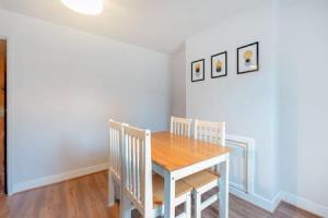克罗伊登Cosy 2-bedroom house in Croydon的一间带木桌和椅子的用餐室