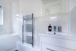 克罗伊登Cosy 2-bedroom house in Croydon的白色的浴室设有水槽和淋浴。