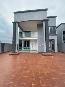 阿克拉Elegant and Cosy Four Bedroom Home in Accra的一座大房子前面设有一个大庭院