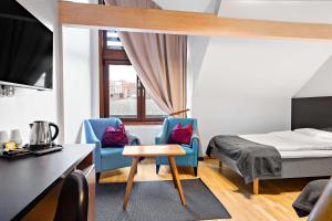 哥德堡Hotell Heden - BW Signature Collection的一间卧室配有一张床和两张蓝色椅子