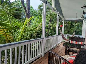 罗阿坦West Bay Roatan - Sunny & Modern Oasis- 2 Bedrooms - 3 min walk to beach的一个带吊床和树木的门廊