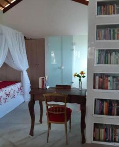 蒙蒂达斯加梅莱拉斯Chalé romântico, com vista panorâmica, para Casais的一间卧室配有一张桌子、一把椅子和一张床