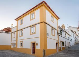 埃尔瓦斯Azinheira Suites Townhouse - Alojamento Turístico的街道上的黄色和白色建筑