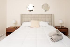 坎昆2BR Moderno en residencial Ombu的一间卧室配有一张带两面镜子的大型白色床