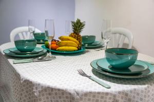 伊瓦格Coliving7 Aparta Hotel & Habitaciones的一张带绿盘和酒杯及水果的桌子