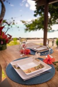 波拉波拉Matira Beach Raitea 1的一张桌子,上面放有盘子和酒杯