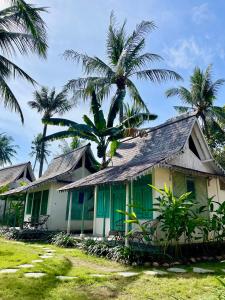 吉利阿尔吉利埃尔椰子旅舍的前面有棕榈树的房子