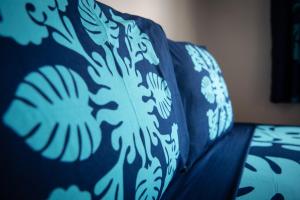 波拉波拉Matira Beach Raitea 1的蓝色的沙发,带蓝色和白色的毯子