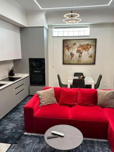 都拉斯Skyen Luxury Apartments的客厅配有红色的沙发和桌子