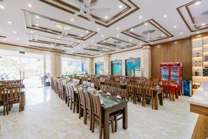 吉婆岛Lang Chai Hotel Cat Ba的一个带木桌和椅子的大型宴会厅