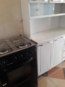 塞古罗港Porto apartamento 6的厨房配有黑炉和白色橱柜。