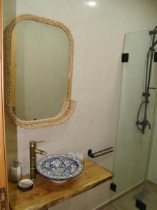 塔姆拉赫特乌兹达尔Dar Makai Surf Hotel的浴室设有水槽和镜子,位于柜台上