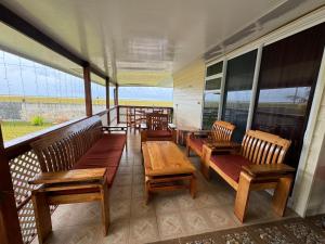 土布艾岛Toamanahere Guesthouse的门廊设有木凳、桌子和窗户