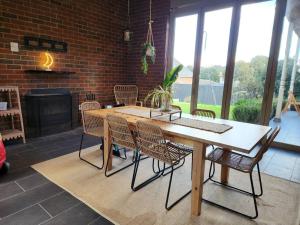 墨尔本Hillcrest Harmony: Luxury in Westmeadows 20% OFF的砖墙房里的桌椅