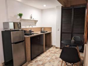 圣何塞德尔卡沃Estudio Bengala的厨房配有冰箱和桌椅