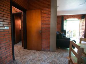 卡内拉Residencial Colling的一间设有砖墙和木门的客厅