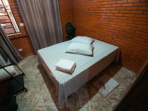 卡内拉Residencial Colling的一间卧室设有一张床和砖墙