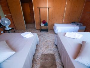卡内拉Residencial Colling的客房设有三张床和风扇。