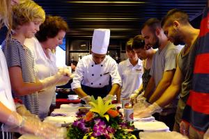 下龙湾Mila Cruises的一群站在厨师身边准备食物的人