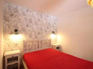 勒蒙多尔Charmant F2 bis au Mont-Dore avec balcon, au pied des pistes, 6 pers, parking, ascenseur - FR-1-415-150的一间卧室配有红色的床和2个床头柜