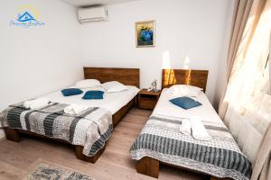 穆里吉奥尔Casa Anastasia的小客房内的两张床,配有蓝色枕头