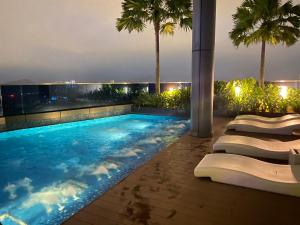 吉隆坡Eaton Residences at Leo的棕榈树建筑屋顶上的游泳池