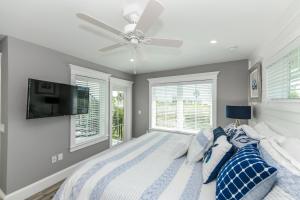 安娜玛丽亚Beach Escape的一间卧室配有一张带吊扇和窗户的床。