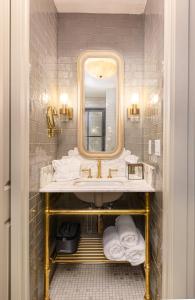 诺克斯维尔Hotel Cleo Knoxville的浴室配有盥洗盆、镜子和毛巾