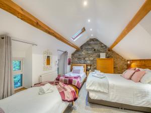 哈雷克诺德法乡村别墅的阁楼卧室设有两张床和石墙