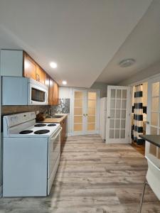 北湾Oakridge的厨房配有白色家电和木制橱柜