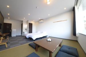 Nakamachiロマンスホテル（Romance Hotel）的卧室配有一张床和一张桌子