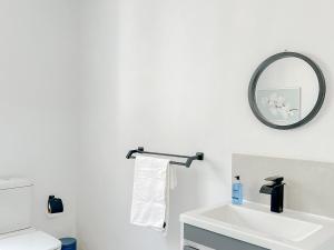 比勒陀利亚Amoris Guesthouse - In Brooklyn的浴室设有白色水槽和镜子
