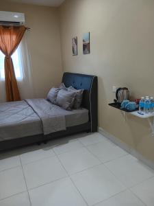 珍南海滩NURUL ROOMSTAY LANGKAWI的一间卧室配有一张蓝色床头板的床