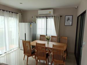 素叻88house suratthani的厨房配有桌椅和冰箱。