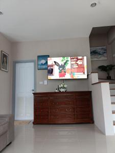 素叻88house suratthani的客厅配有梳妆台和墙上的电视