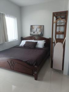 素叻88house suratthani的一间卧室配有一张带木制床头板的床